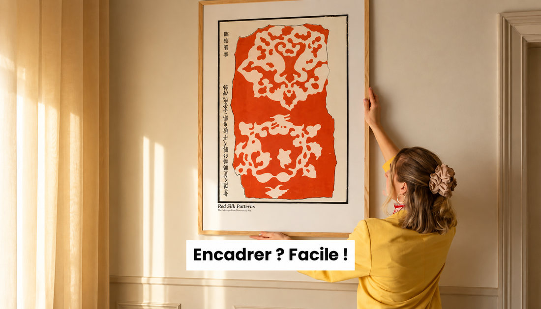 Femme installant une grande affiche encadrée sur un mur dans un intérieur lumineux