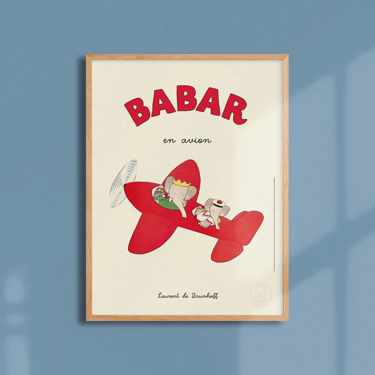 Affiche Babar en avion encadrée sur fond bleu