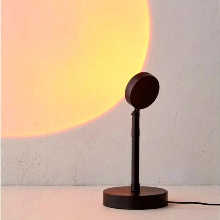 Lampe coucher de soleil projetant un halo lumineux chaud sur un mur